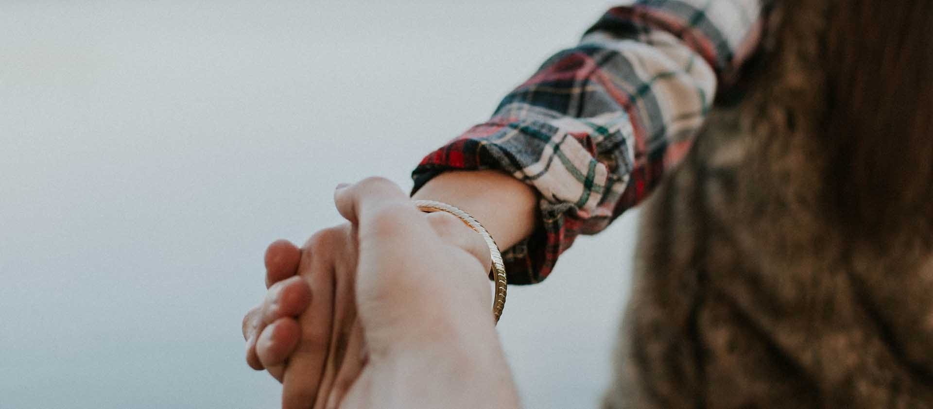 Twee handen die elkaar vasthouden