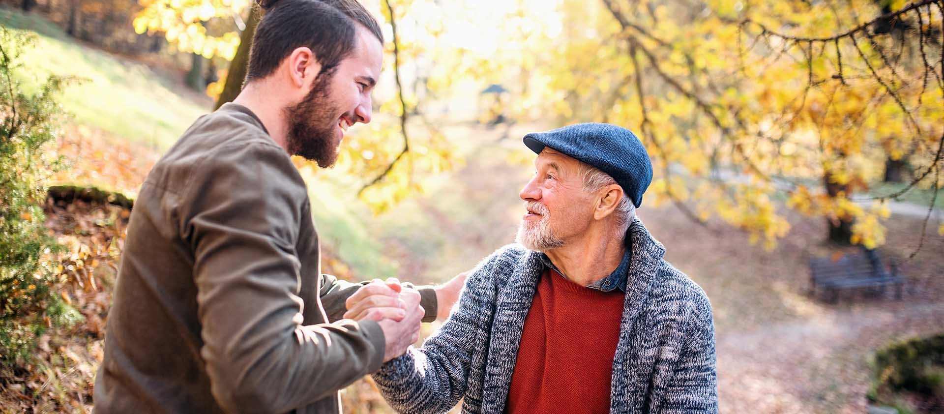 Een vader en zoon die in het bos zijn en elkaar een hand geven