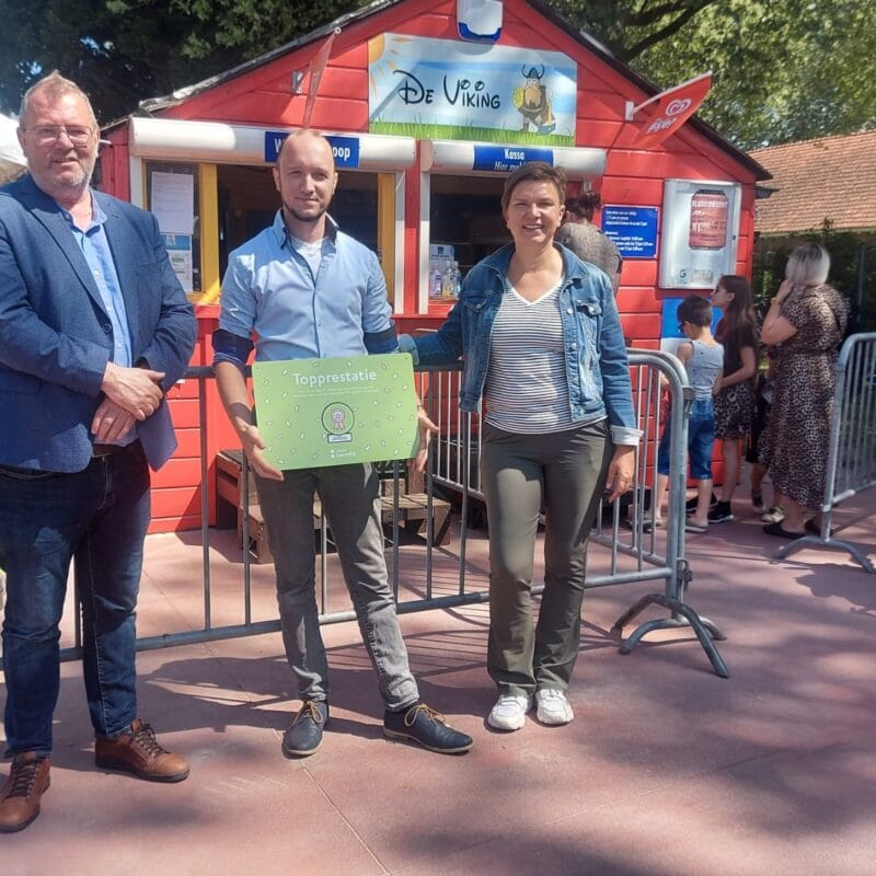 Twee mannen en een vrouw, waarvan een man de topprestatiebadge voeding vast heeft