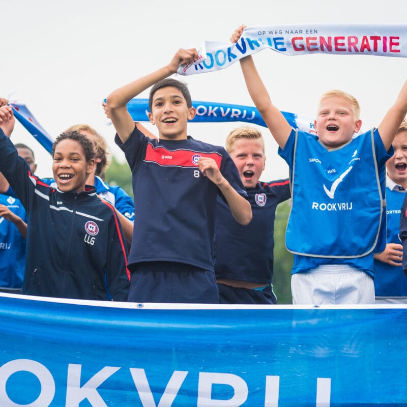 Juichende kinderen vanwege een rookvrije generatie met spandoeken