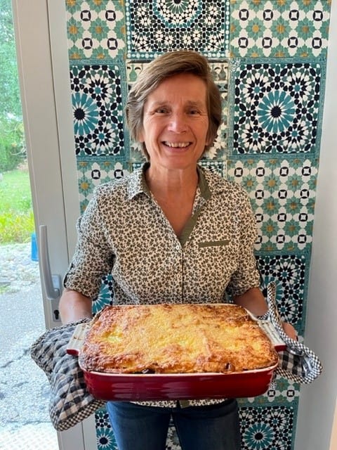Mathil Sanders houdt een grote schaal zelf gemaakte lasagne met courgette vast